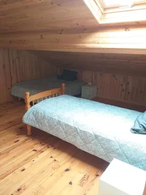 a bedroom with two beds in a attic at Belle maison proche de la ville et du lac in Belcaire