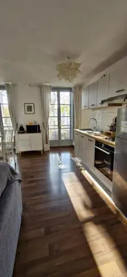 a large kitchen with wooden floors and white cabinets at les jardins de l'archevêché in Narbonne