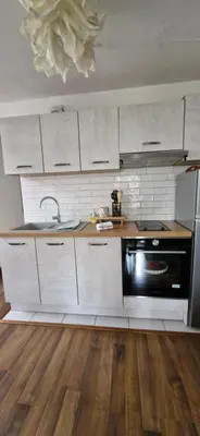 a kitchen with white cabinets and a sink and a stove at les jardins de l'archevêché in Narbonne