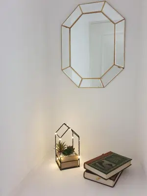 a mirror and books on a table with a lamp at les jardins de l'archevêché in Narbonne