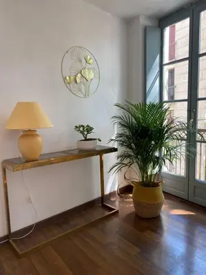a room with a table with two plants and a lamp at les jardins de l'archevêché in Narbonne