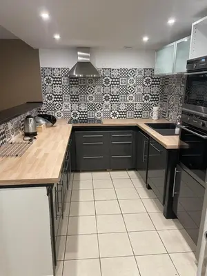 a kitchen with black and white tiles on the wall at L’oustal in Vaudreuille