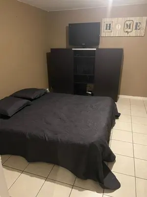 a bedroom with a bed and a flat screen tv at L’oustal in Vaudreuille