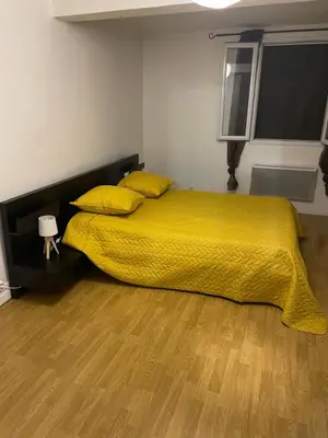 a bedroom with a bed with a yellow bedspread and yellow pillows at L’oustal in Vaudreuille
