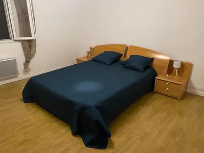 a bedroom with a large bed with a blue bedspread at L’oustal in Vaudreuille