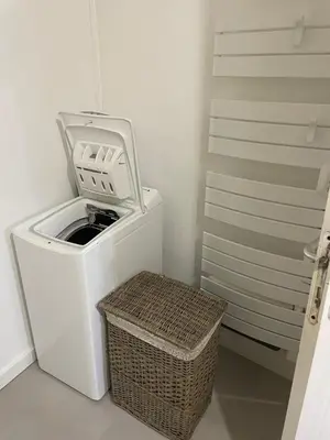 a washing machine and a basket in a room at L’oustal in Vaudreuille