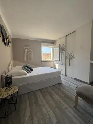 a bedroom with a large white bed in a room at Le Lamourguier in Narbonne