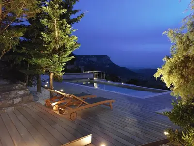 a pool with a bench on a deck at night at Lodge d'Œnotourisme avec vue imprenable ! in Vingrau