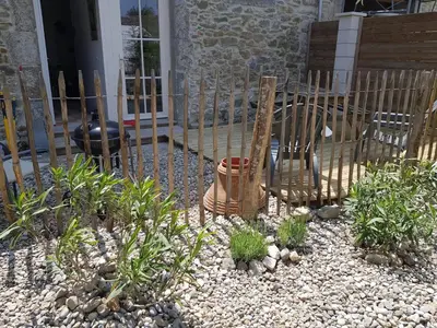 a room with a stone wall and a table and chairs at Gîte Aznavour près de Carcassonne in Pennautier