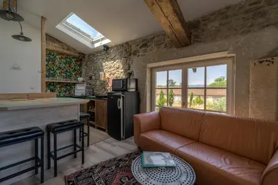 a leather couch in a living room with a window at Gîte Aznavour près de Carcassonne in Pennautier