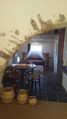 a room with a bed and a table and baskets at Gîte dans ancienne bergerie en pleine garrigue in Fraissé-des-Corbières