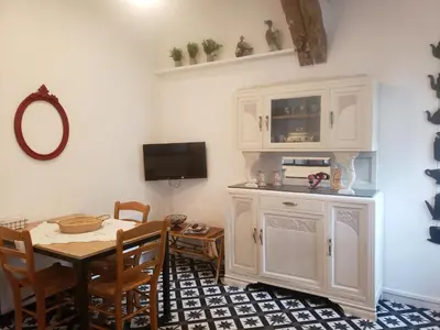 a dining room with a table and a tv at le balcon in Camps-sur-lʼAgly
