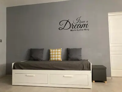 a bedroom with a bed with a have a dream sign on the wall at COLORS by Reine du Sud, proche des Grands Buffets in Narbonne
