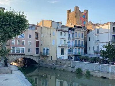 a bridge over a river in a city with buildings at COLORS by Reine du Sud, proche des Grands Buffets in Narbonne