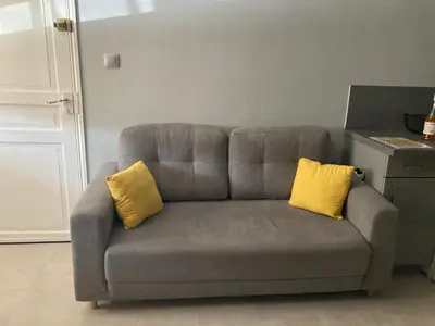 a gray couch with two yellow pillows on it at COLORS by Reine du Sud, proche des Grands Buffets in Narbonne