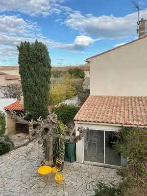 a patio with yellow chairs and a house at COLORS by Reine du Sud, proche des Grands Buffets in Narbonne
