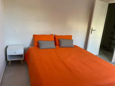 a bedroom with an orange bed with two pillows at COLORS by Reine du Sud, proche des Grands Buffets in Narbonne