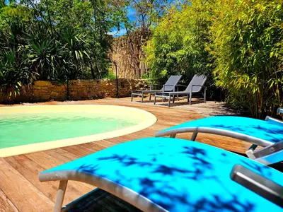 a patio with chairs and a pool of water at Chambre d'hôtes Les Berges de l'Aude - B&B - Proche Canal du midi & Carcassonne in Puicheric