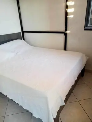 a white bed in a room with lights on it at résidence les amandines in Gruissan