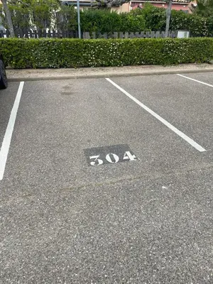 a parking lot with a handicapped sign on the ground at résidence les amandines in Gruissan