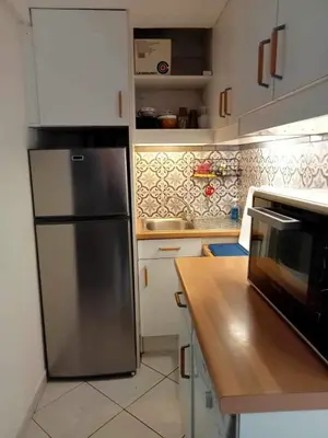 a kitchen with a stainless steel refrigerator and a counter at résidence les amandines in Gruissan