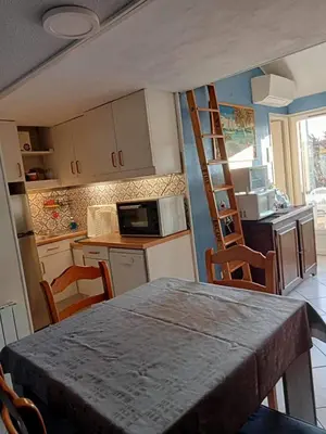 a kitchen with a table and chairs in a room at résidence les amandines in Gruissan