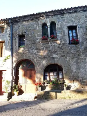 an old stone building with flower boxes on the windows at Chambre d'hôte Au Jardin Le clos des vins d'Anges in Saint-Pierre-des-Champs
