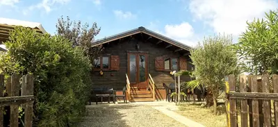 a wooden house with a wooden door and a fence at Chalet en bois 