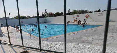 a view of a swimming pool through a fence at Chalet en bois 