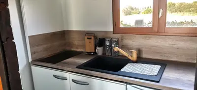 a kitchen counter with a sink and a window at Chalet en bois 