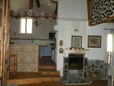 a living room with a stone fireplace in a building at GRANDE MAISON FAMILIALE in Escouloubre