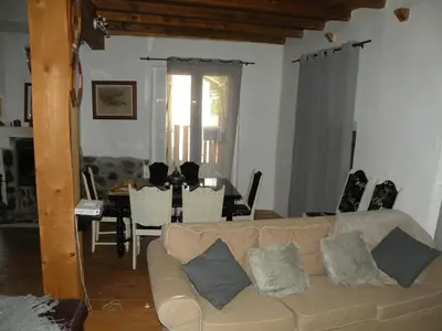 a living room with a couch and a dining room at GRANDE MAISON FAMILIALE in Escouloubre