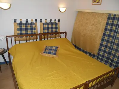 a bedroom with a bed with a yellow blanket at GRANDE MAISON FAMILIALE in Escouloubre
