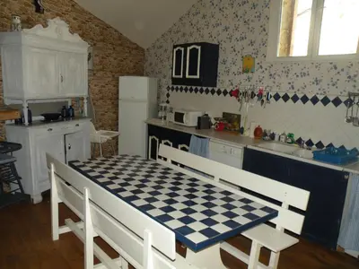 a kitchen with a checkered table in a kitchen at GRANDE MAISON FAMILIALE in Escouloubre