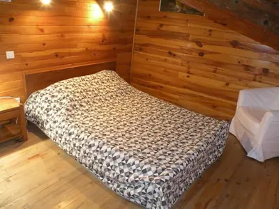 a bedroom with a bed in a room with wooden walls at GRANDE MAISON FAMILIALE in Escouloubre