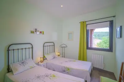 two beds in a room with a window at Côté Vignes à Bélesta in Bélesta