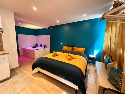 a bedroom with a bed and a blue wall at EDEN SUITE - Jacuzzi - Parking - Clim by Narbana in Narbonne