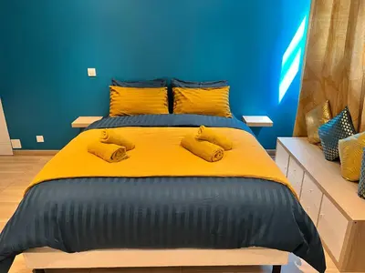 a bedroom with a yellow bed with yellow pillows at EDEN SUITE - Jacuzzi - Parking - Clim by Narbana in Narbonne