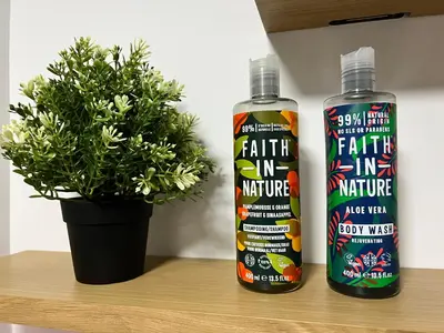 two bottles of faith in nurture sitting on a table with a plant at EDEN SUITE - Jacuzzi - Parking - Clim by Narbana in Narbonne