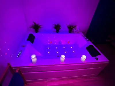 a purple room with a tub with candles in it at EDEN SUITE - Jacuzzi - Parking - Clim by Narbana in Narbonne