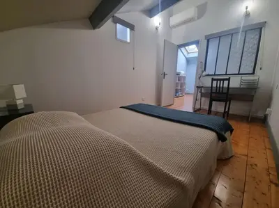a bedroom with a bed and a table and a chair at La Marceline 1 - Appart entre mer et canal du midi en pays Cathare in Saint-Marcel