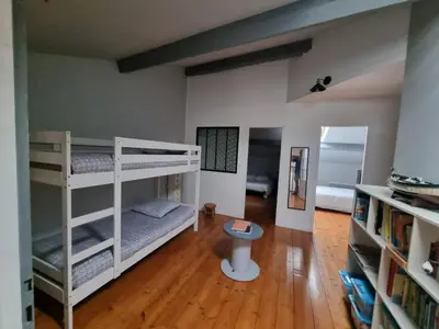 a room with two bunk beds and a wooden floor at La Marceline 1 - Appart entre mer et canal du midi en pays Cathare in Saint-Marcel
