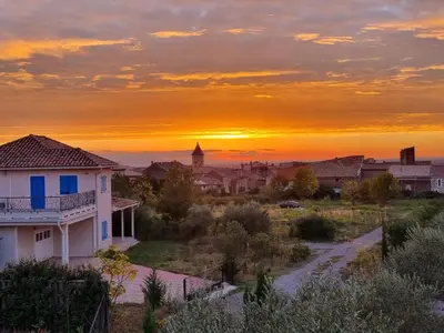 a sunset over a small town with a house at Clos des Oliviers in Oupia