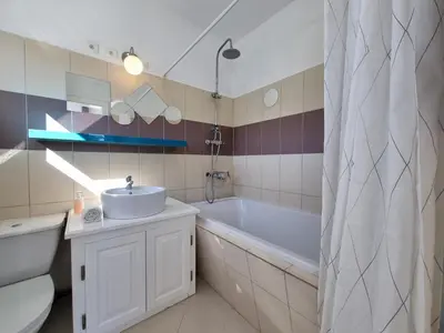 a bathroom with a tub and a sink and a tubermottermott at Clos des Oliviers in Oupia