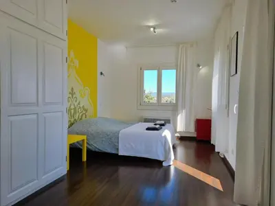 a bedroom with a bed and a window at Clos des Oliviers in Oupia