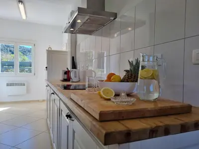 a kitchen counter with a bowl of fruit on a cutting board at Clos des Oliviers in Oupia