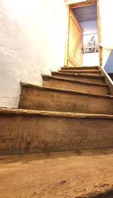 a set of wooden stairs with a wooden door at Les pieds en éventail in Lignairolles