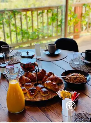a table with a plate of pastries and orange juice at Les pieds en éventail in Lignairolles