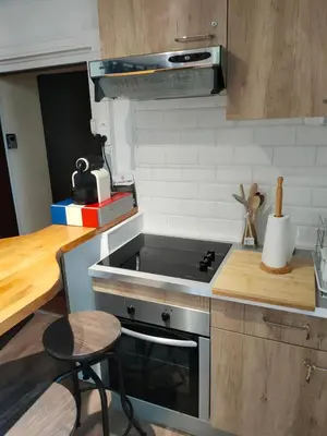 a small kitchen with a stove and a stool at Le quai in Port-la-Nouvelle
