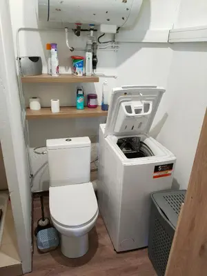 a bathroom with a toilet and a sewing machine at Le quai in Port-la-Nouvelle